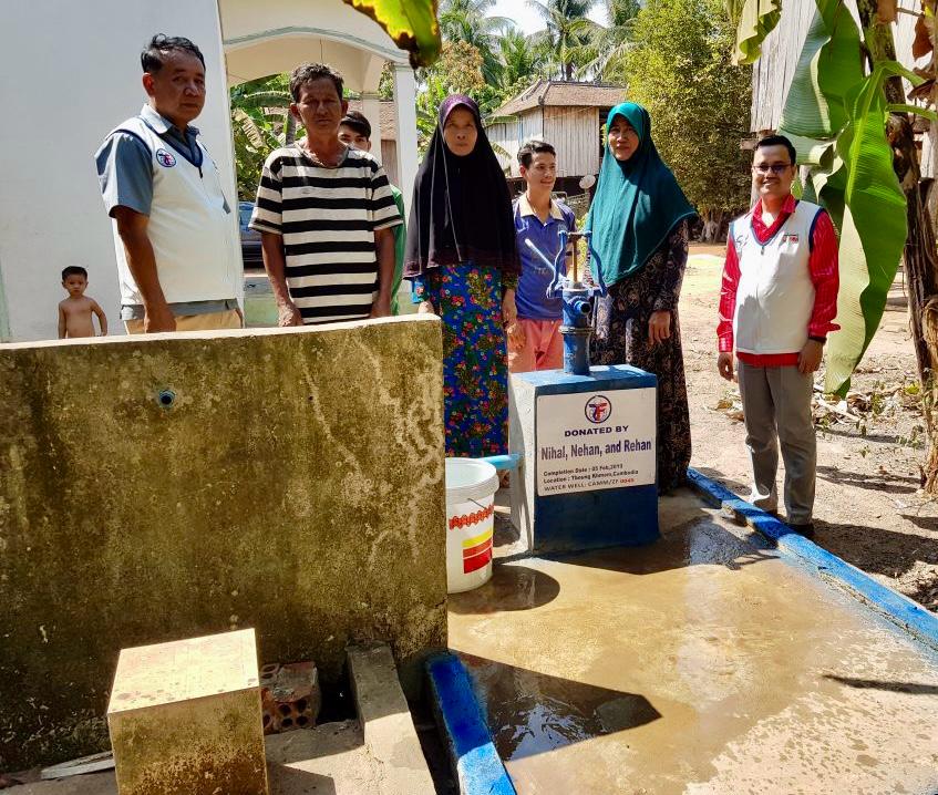 Community members gathered around a completed water well in Cambodia